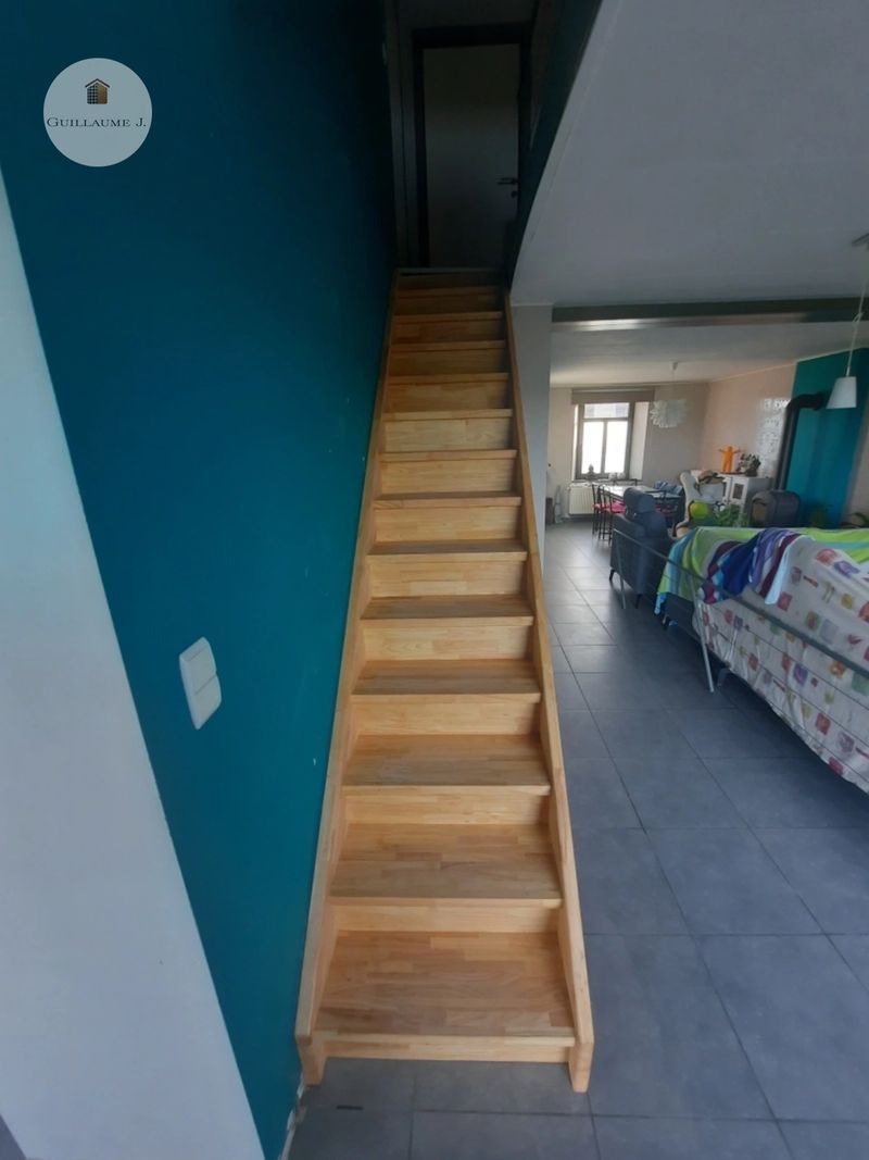 Escalier droit en bois contre un mur vert – Guillaume Menuiserie