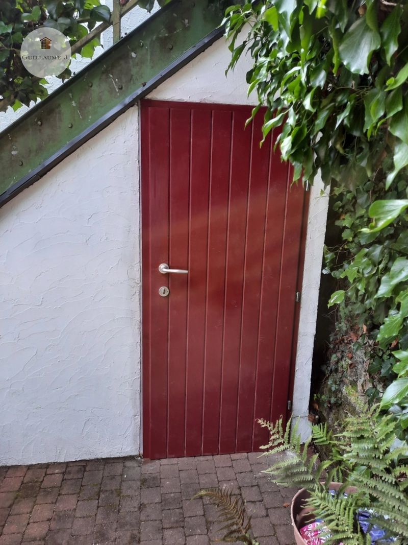 Porte extérieure rouge sous escalier – Guillaume Menuiserie